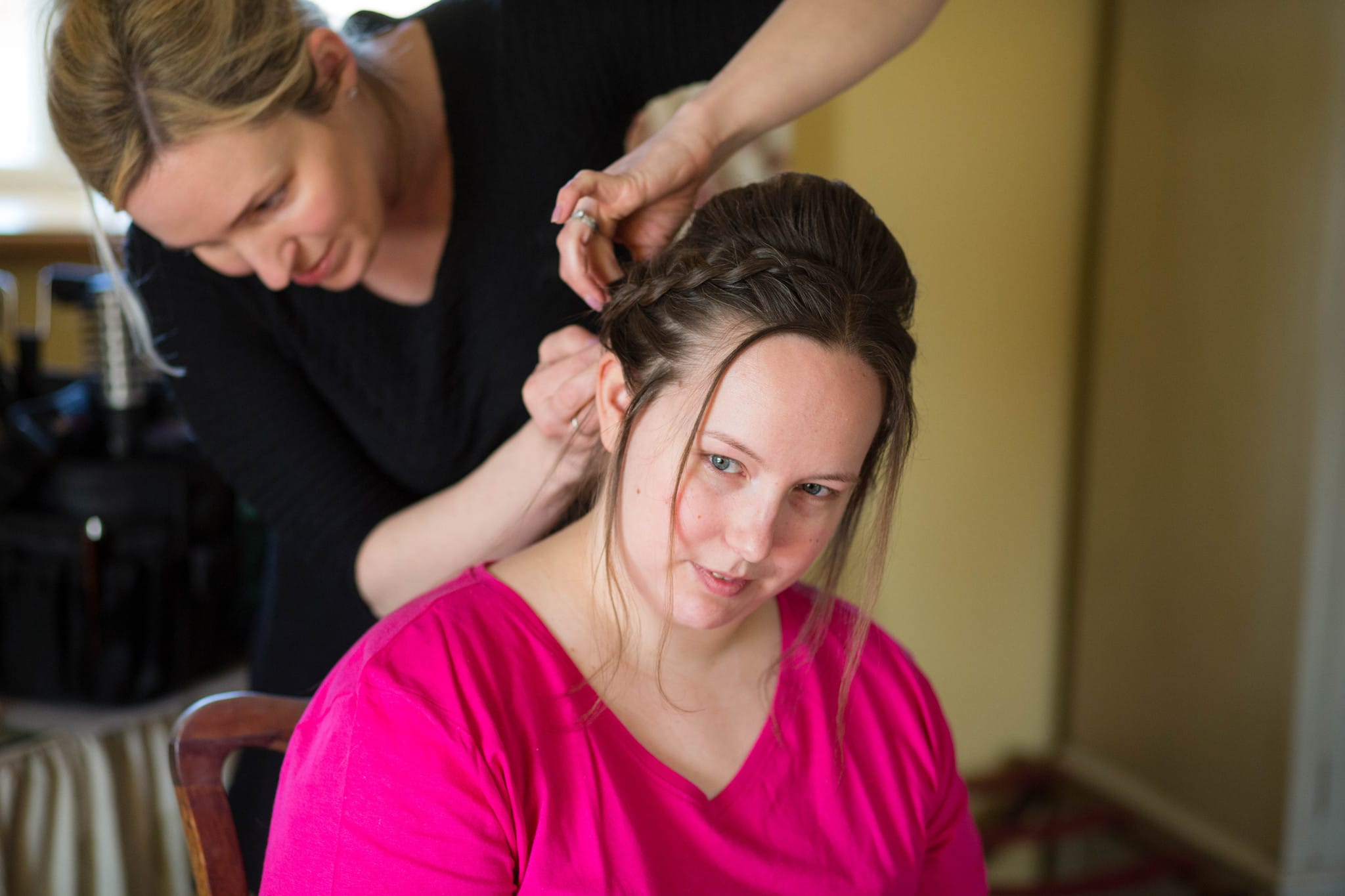 Bride in bright pink t shirt having hair done Delbury Hall