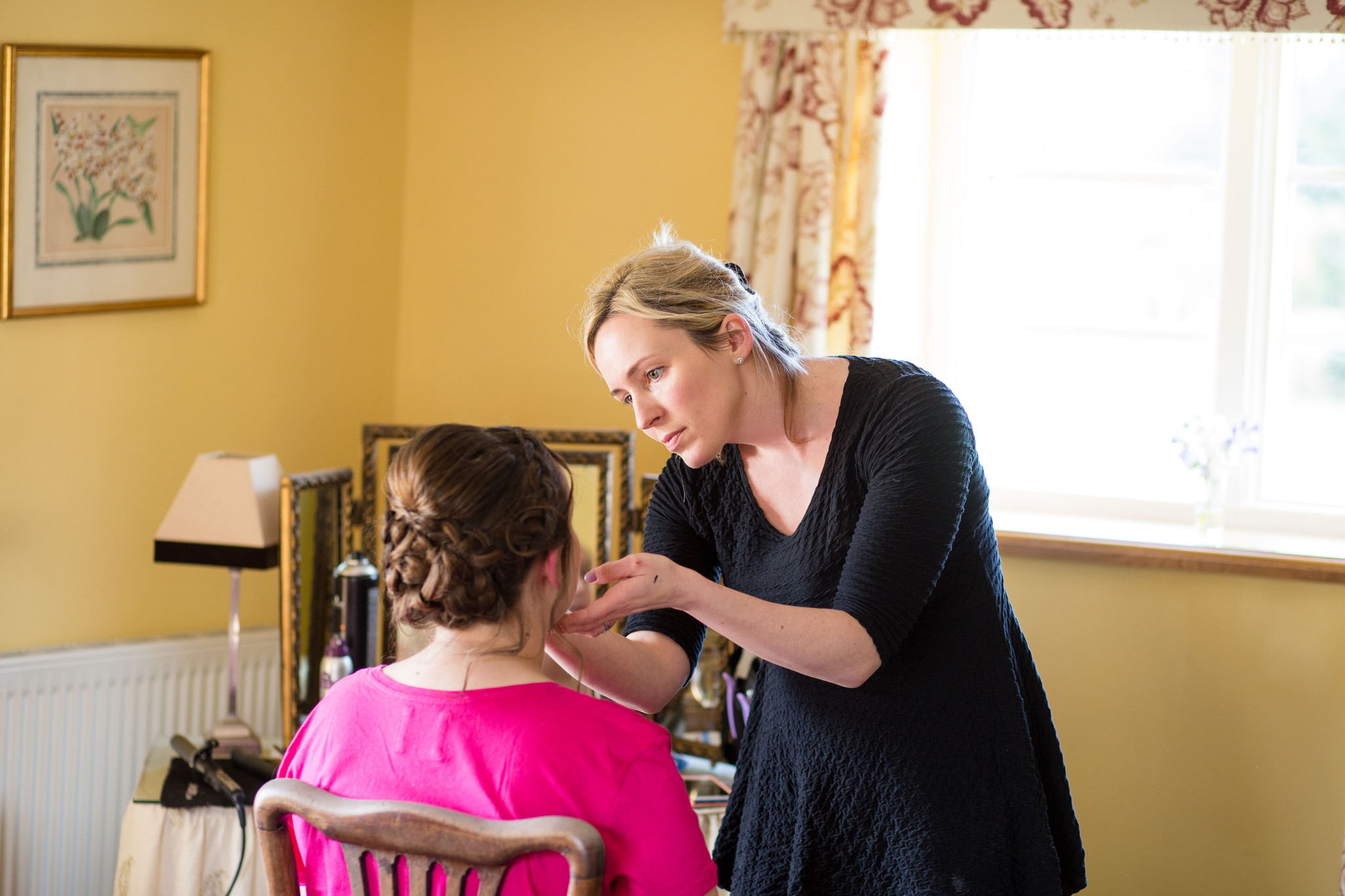 Having make up done bride in bright pink t shirt 