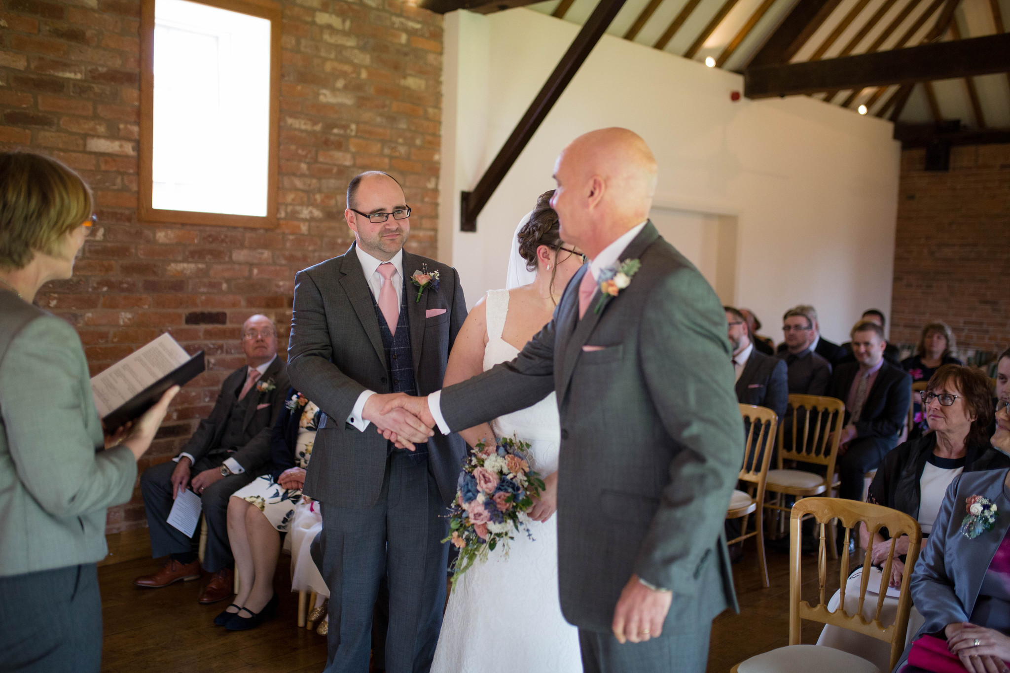 Groom and father of the bride handshake Delbury Hall indoor ceremony