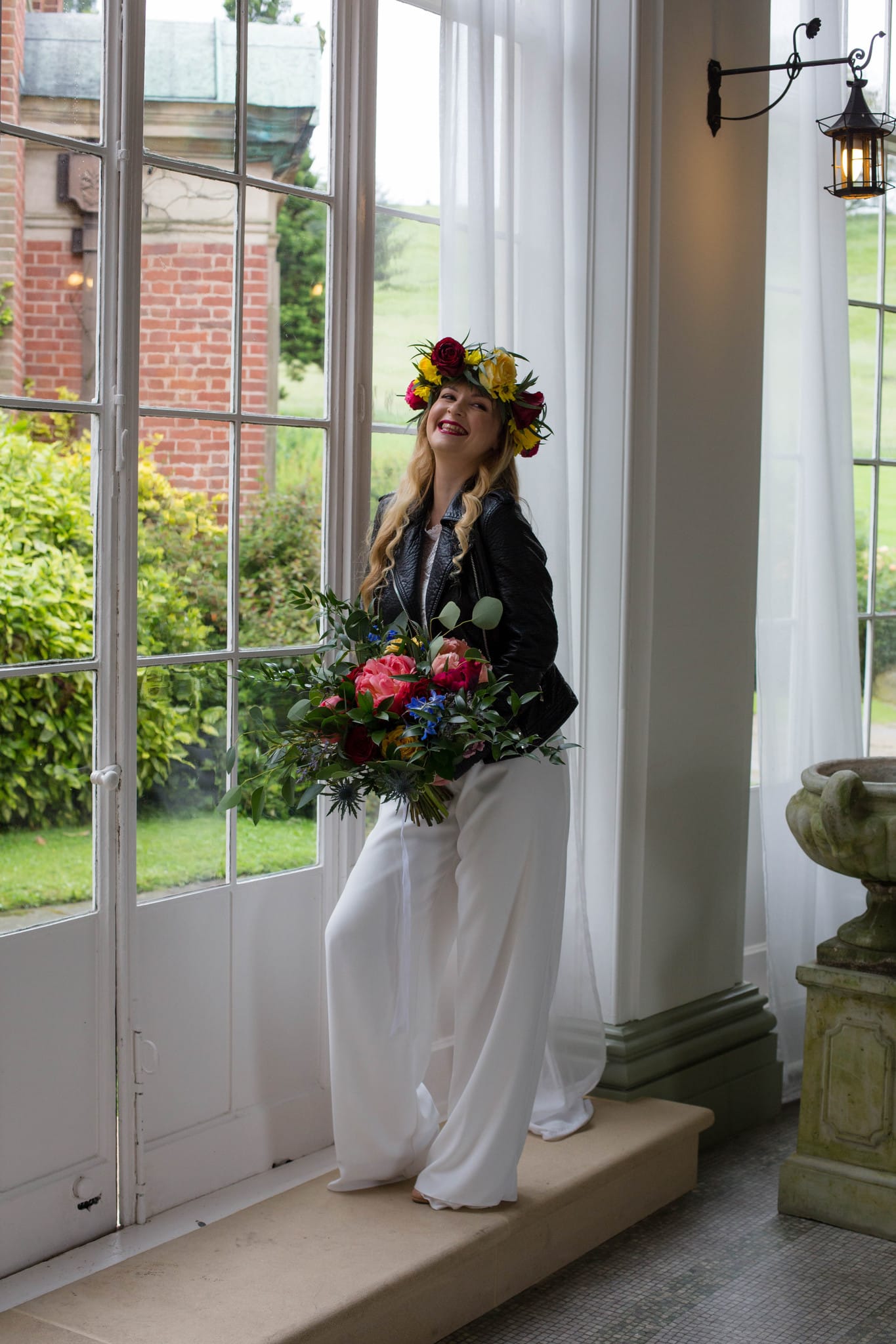 Boho Bride wearing flower crown and leather jacket and bridal jumpsuit