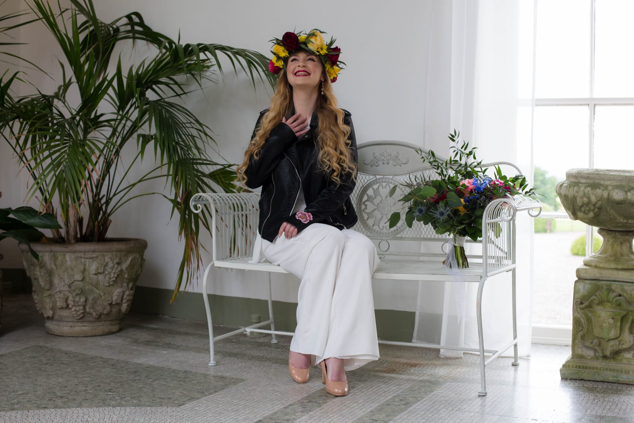 Boho Bride wearing flower crown and leather jacket and bridal jumpsuit