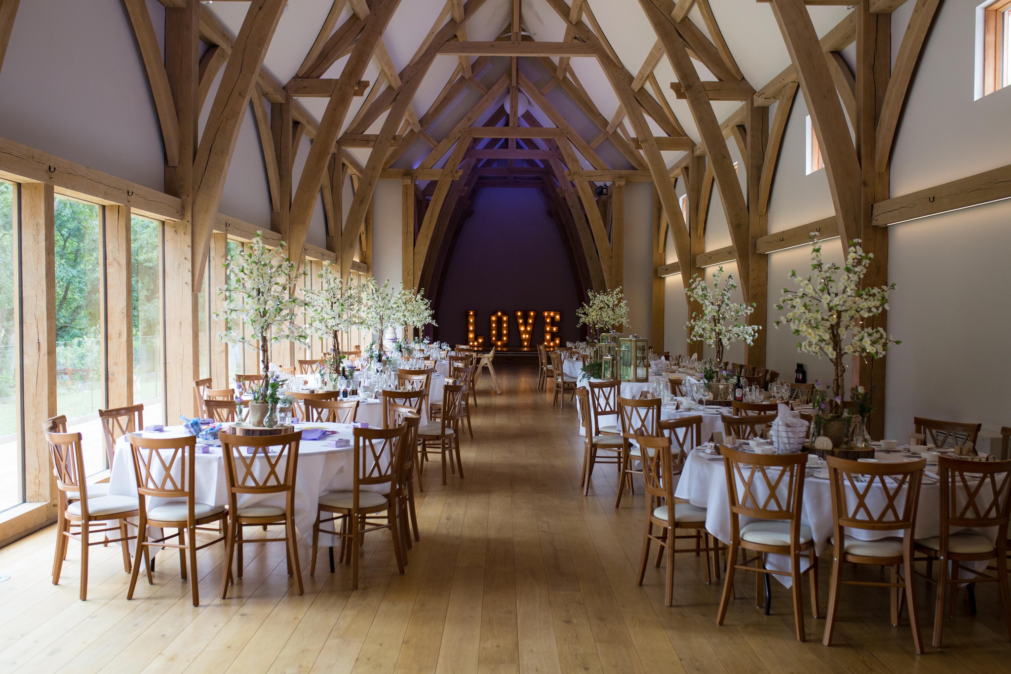 Mill Barns wedding venue interior dressed with blossom trees and light up love letters