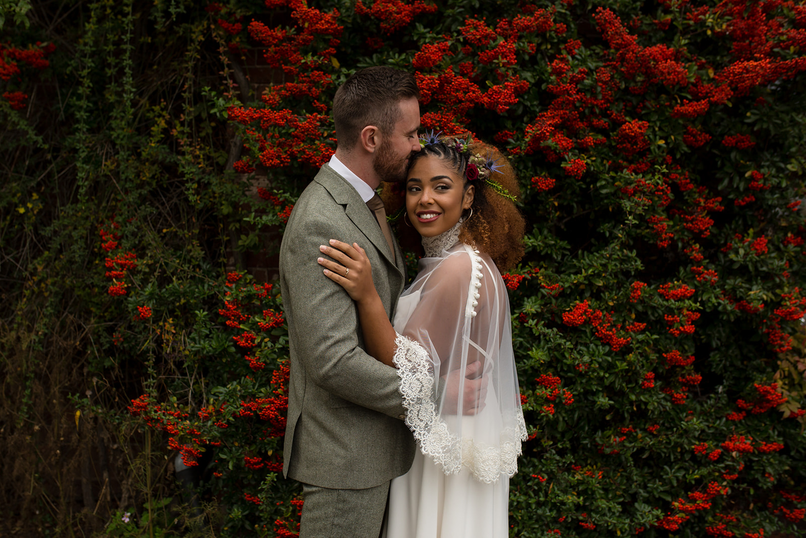 Couple on their wedding day in front of red berries