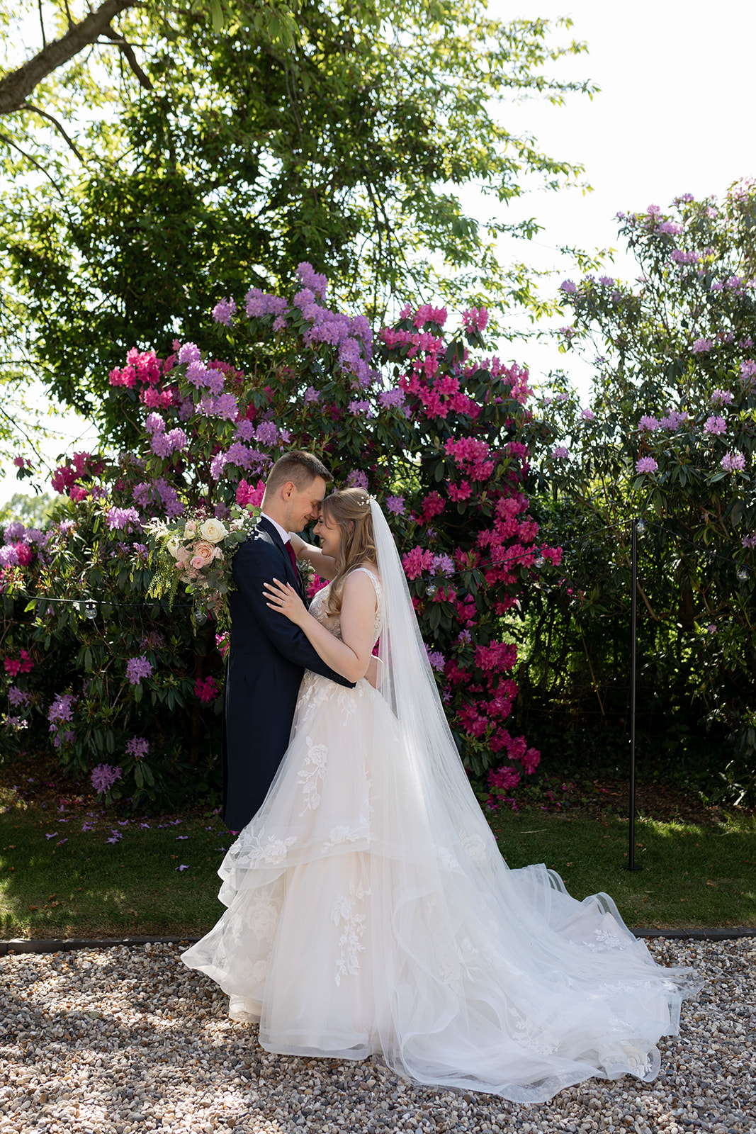 Couple on wedding day in front of colourful flowers