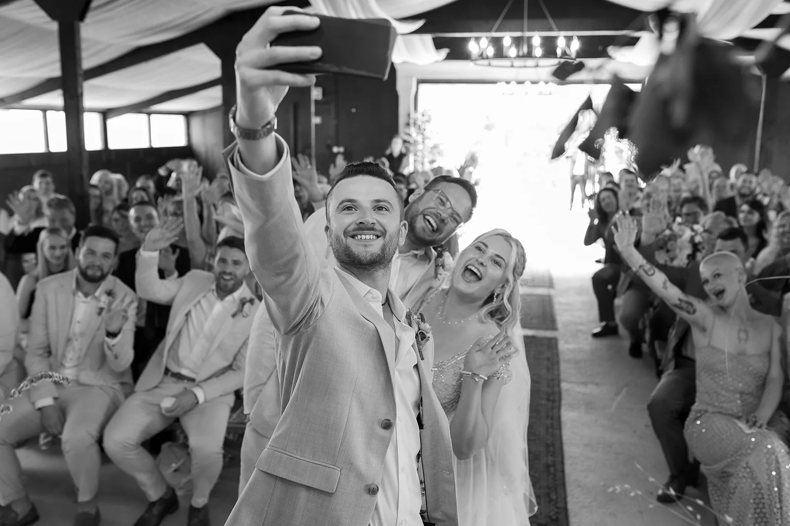 Couple and celebrant on wedding day in black and white