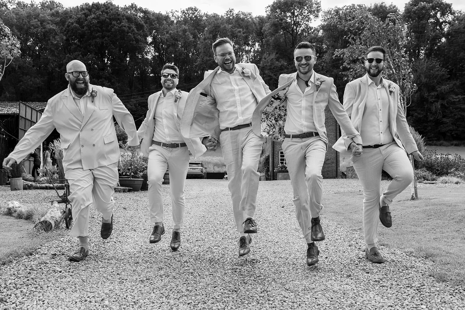 Rhyse Farm wedding venue, groomsmen skip along towards the camera
