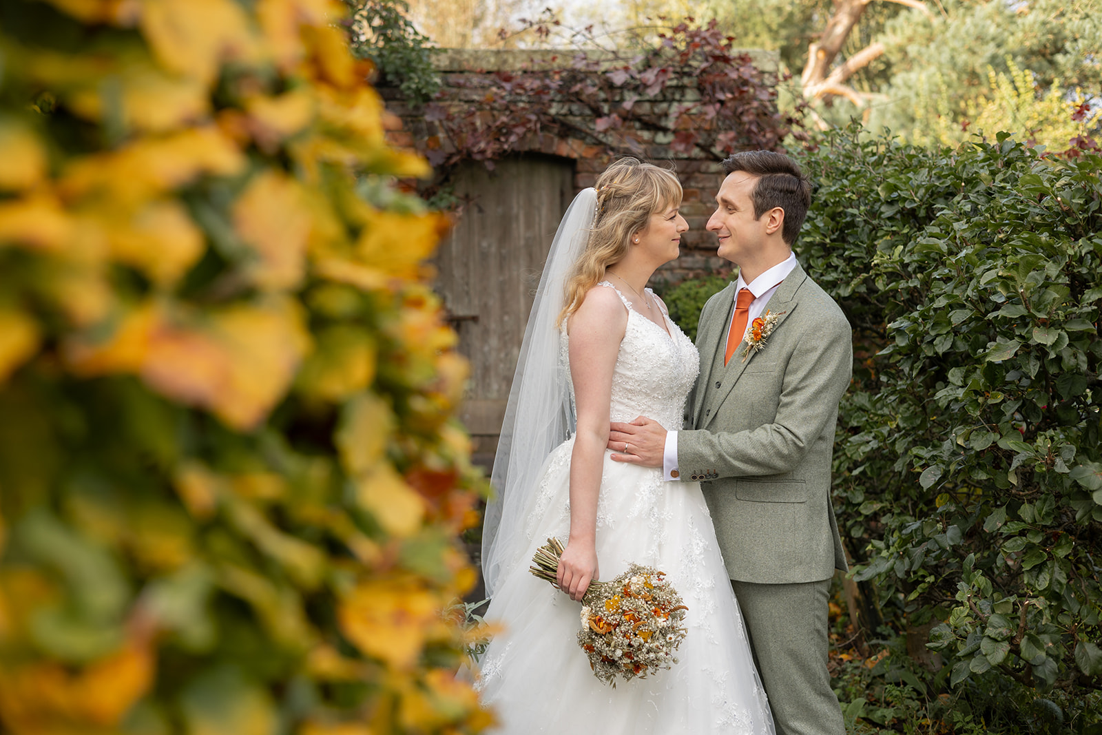 Pimhill Barn wedding gardens in autumn with couple by walled garden