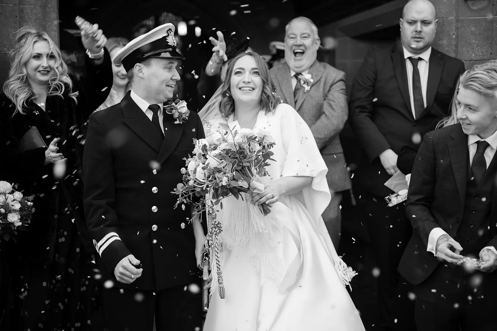 Telford Winter Wedding black and white wedding image showing a group within a shower of confetti