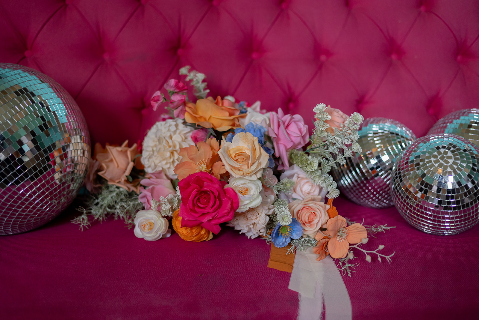 Walcot Hall wedding Shropshire A bright pink sofa with disco balls and a colourful bouquet of flowers