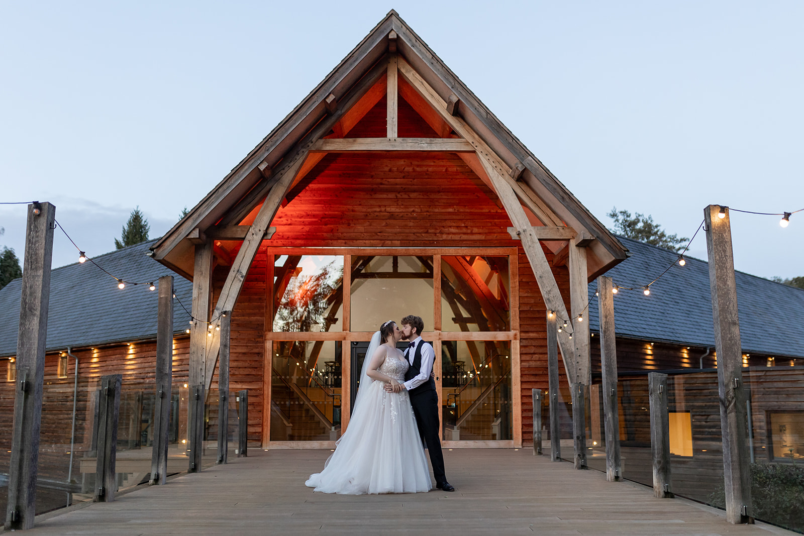 Mill Barns Winter wedding A couple on their wedding day at The Mill Barns Shropshire wedding venue at dusk. The venue is lit up.